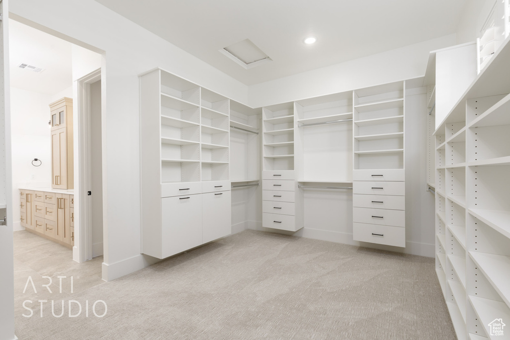 Walk in closet with light colored carpet