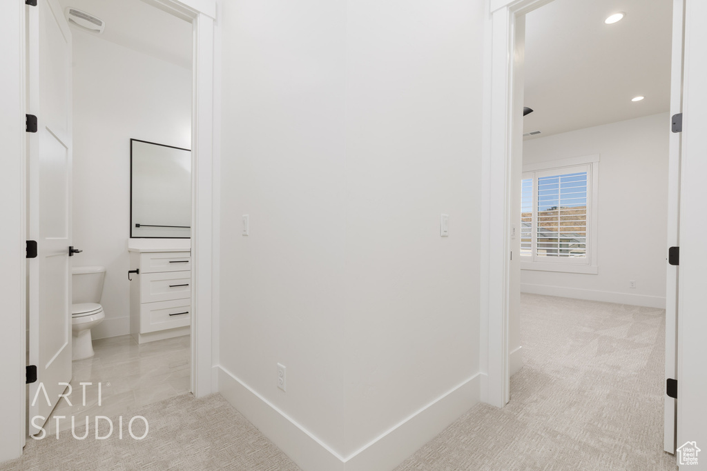 Hallway with recessed lighting and light colored carpet
