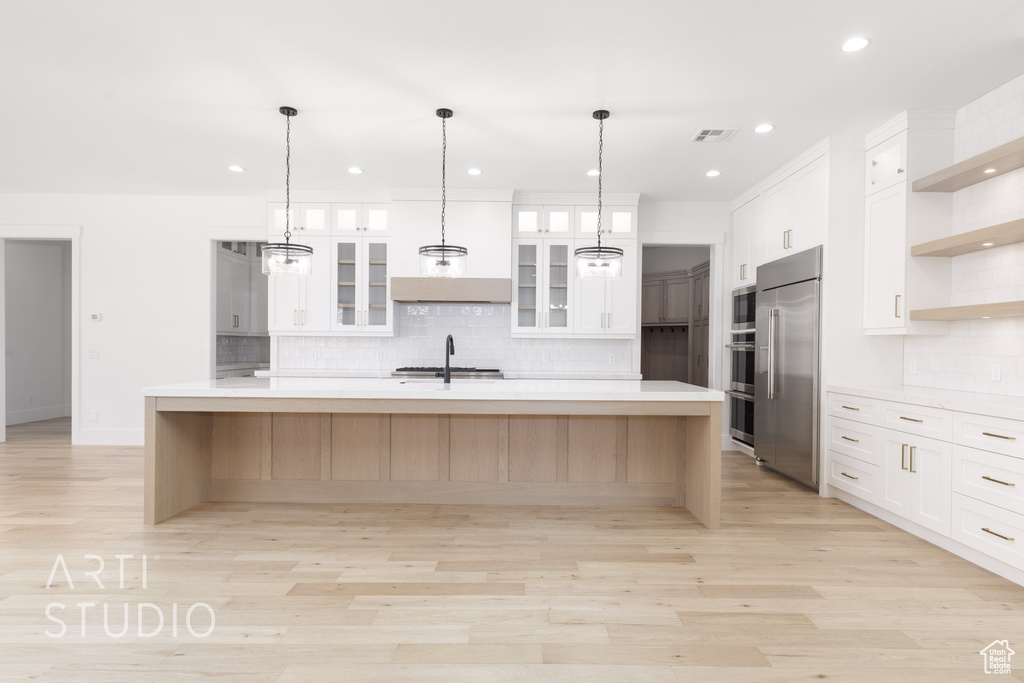 Kitchen featuring built in appliances, open shelves, light countertops, decorative backsplash, and recessed lighting