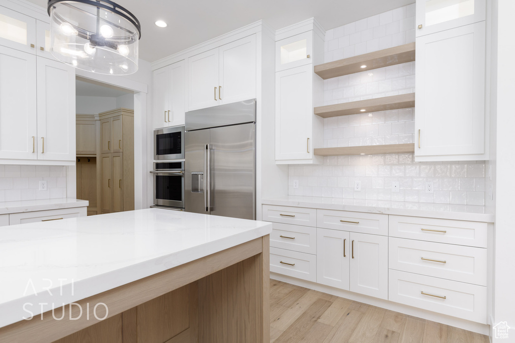 Kitchen with built in appliances, open shelves, tasteful backsplash, white cabinetry, and recessed lighting