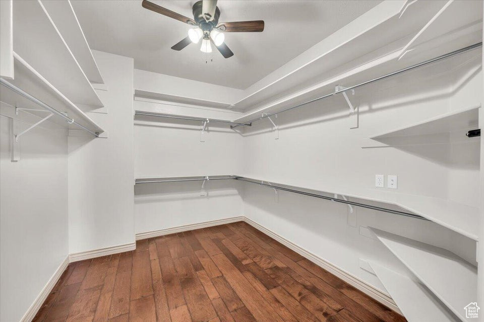 Walk in closet with wood-type flooring and a ceiling fan