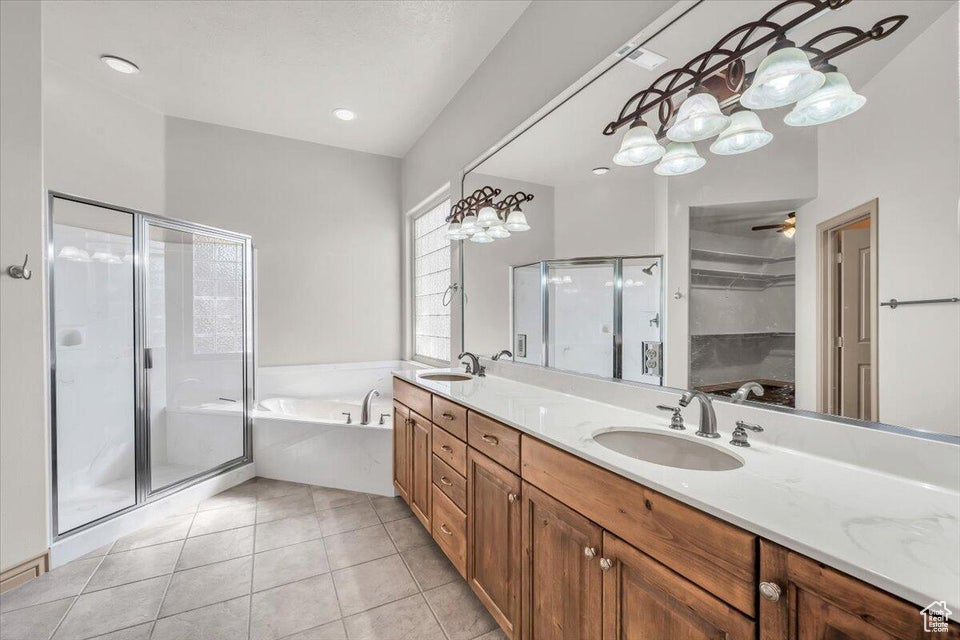 Bathroom featuring a garden tub, a shower stall, double vanity, and tile patterned flooring