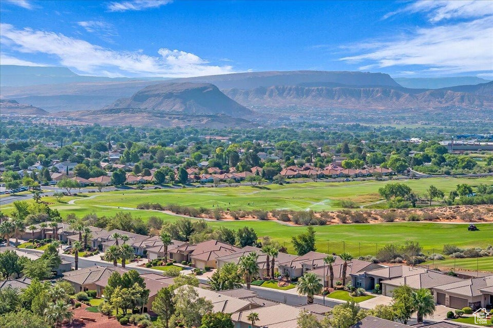 Aerial view of residential area featuring a mountain backdrop and a local golf course
