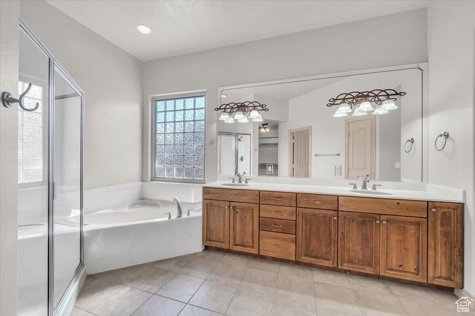 Bathroom featuring a garden tub, double vanity, tile patterned flooring, and a stall shower