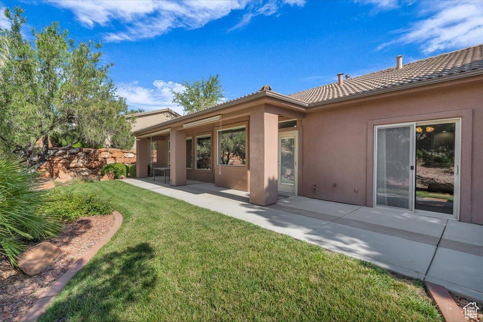 Back of property featuring stucco siding, a tile roof, a yard, and a patio area