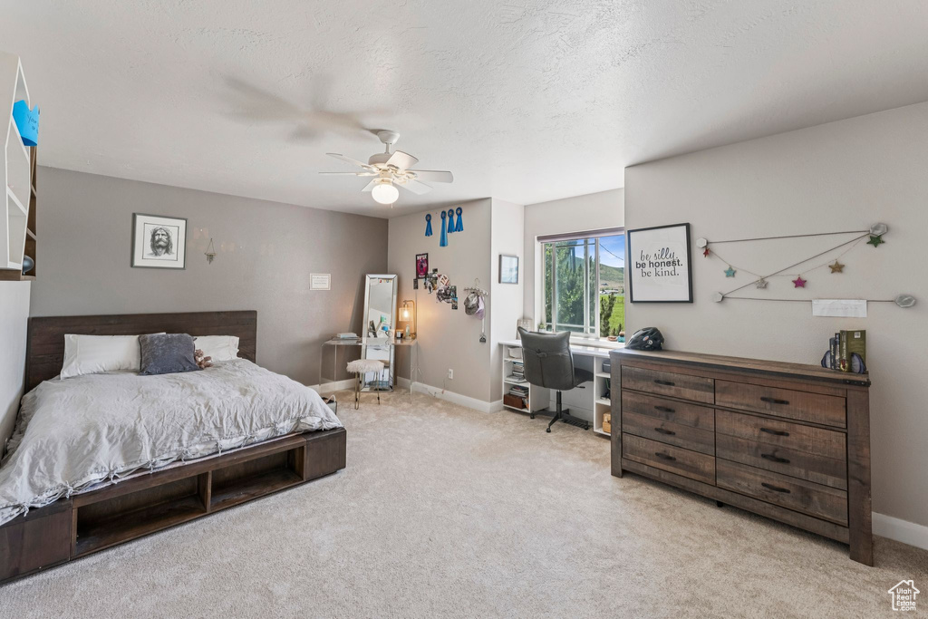 Bedroom featuring an office area, carpet floors, and a ceiling fan
