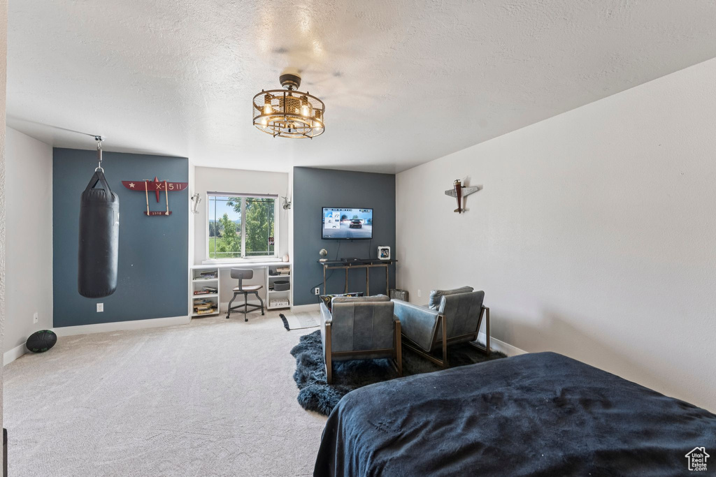 Carpeted bedroom with a chandelier and a textured ceiling