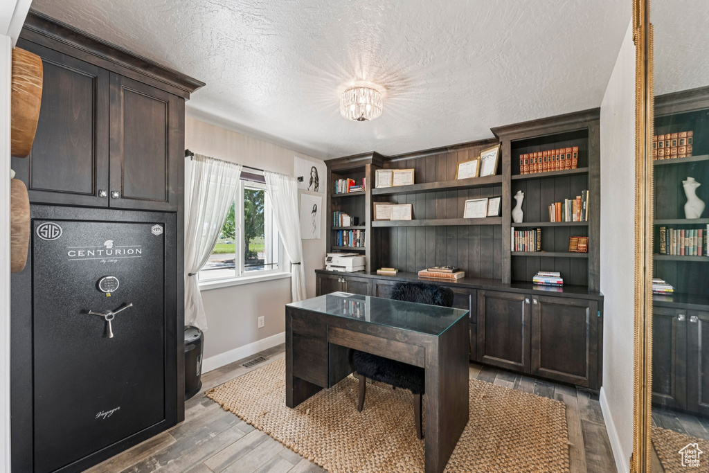 Office with wood finished floors and a textured ceiling
