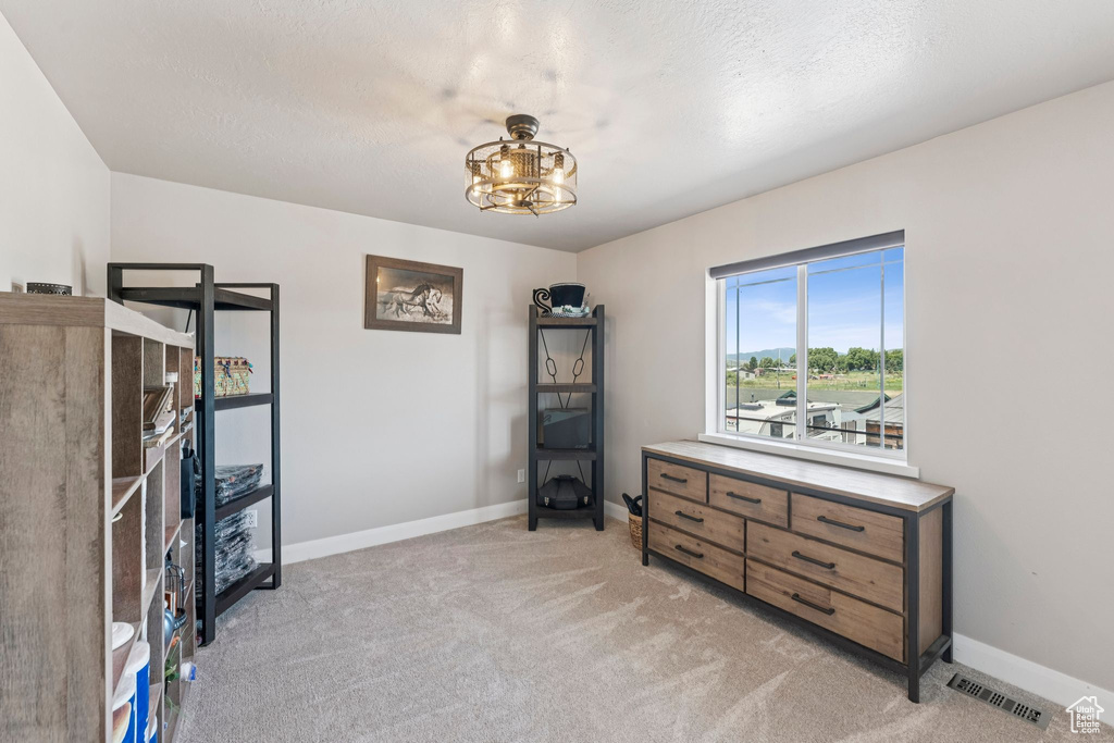 Living area featuring light carpet and a chandelier