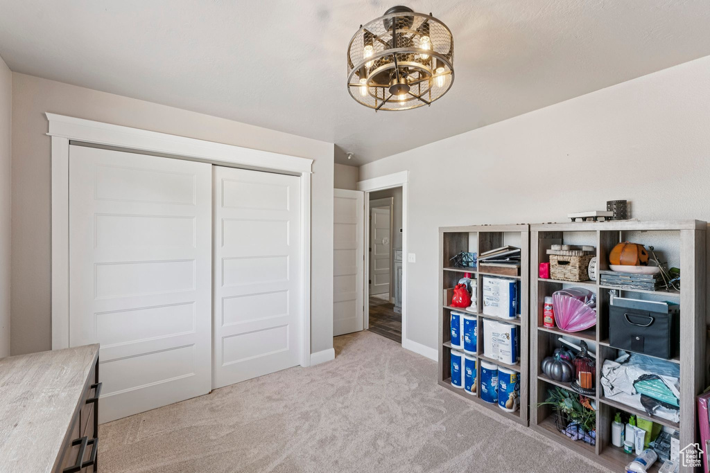 Bedroom featuring carpet floors, a chandelier, and a closet