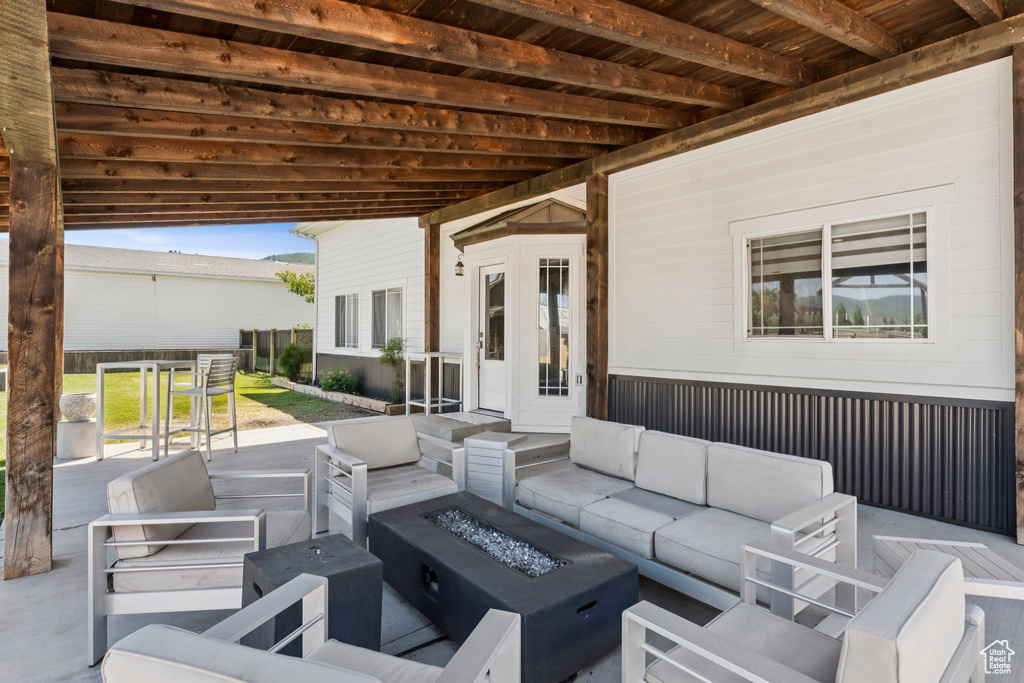 View of patio with an outdoor living space with a fire pit