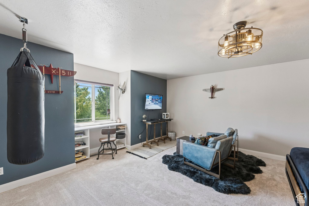 Carpeted living room with baseboards and a textured ceiling
