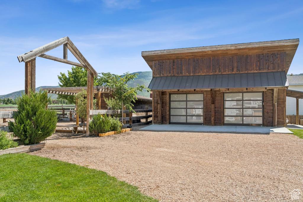 Detached garage with dirt driveway and a mountain view