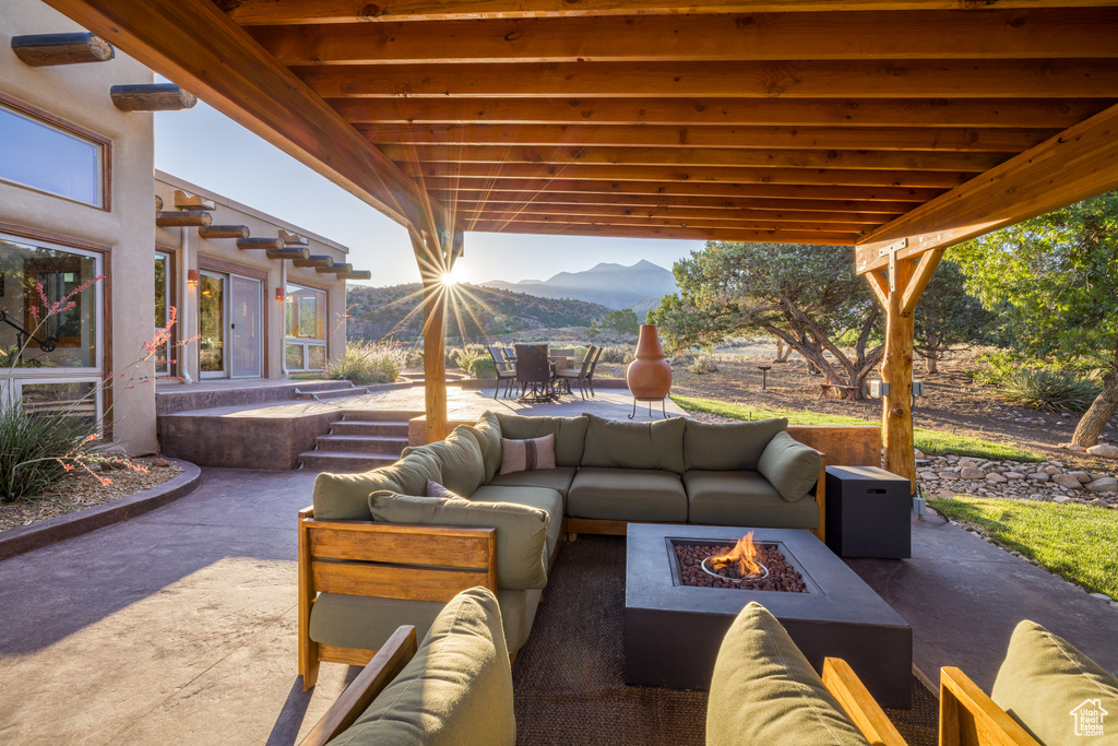 View of patio / terrace with an outdoor living space with a fire pit, a mountain view, and outdoor dining area