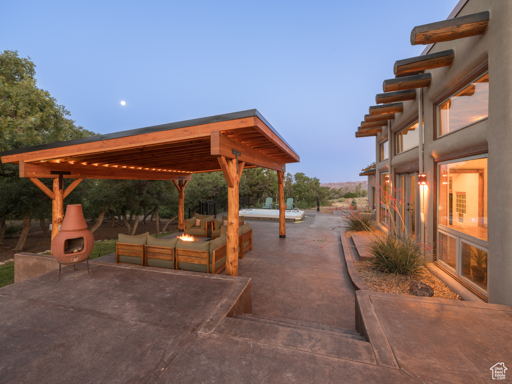 View of patio featuring an outdoor living space with a fire pit