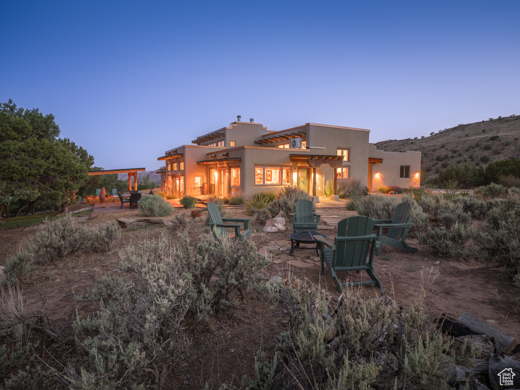 Rear view of house featuring a patio area and a fire pit