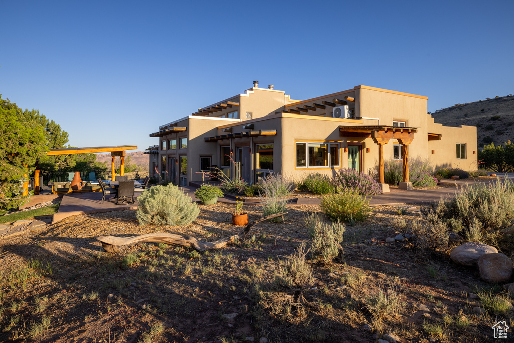 Back of property with stucco siding and a patio area