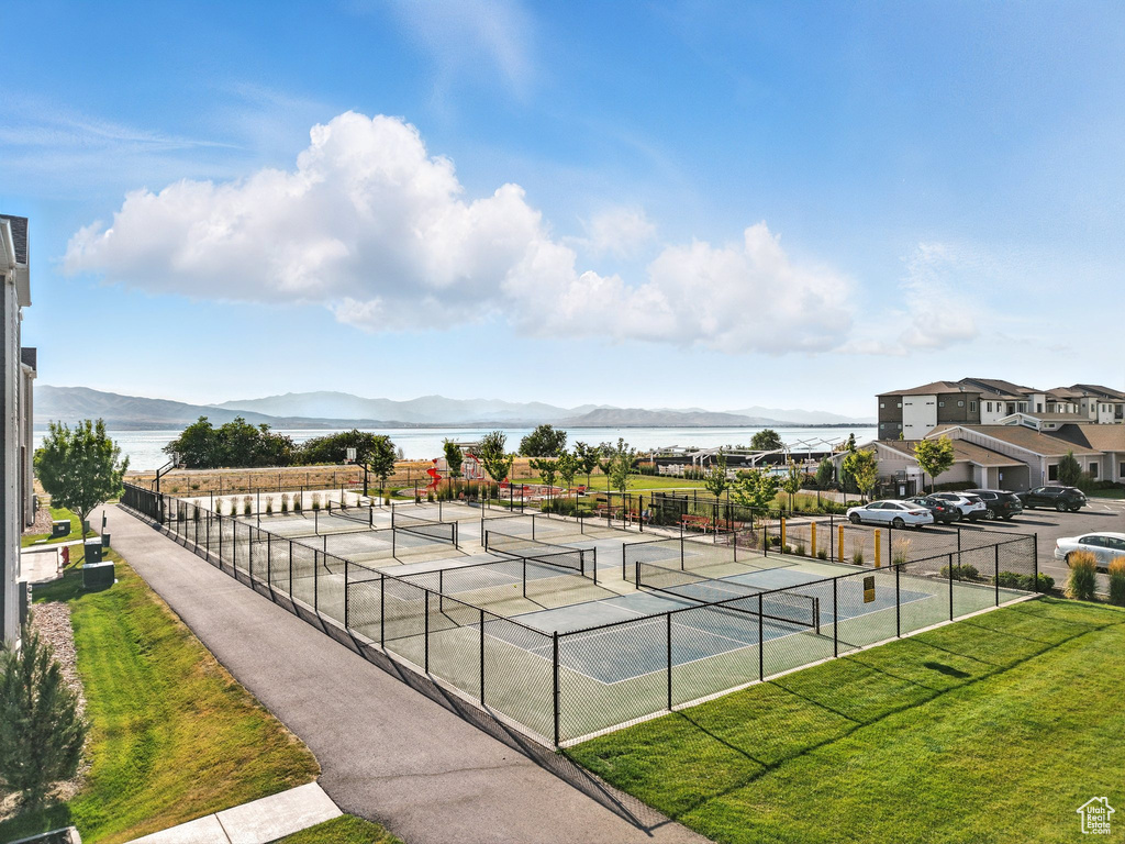 View of tennis court featuring a water and mountain view