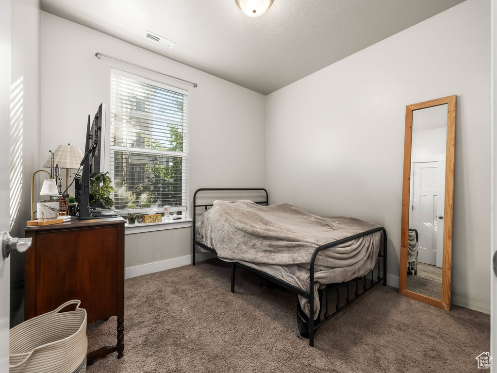 Bedroom featuring carpet and baseboards