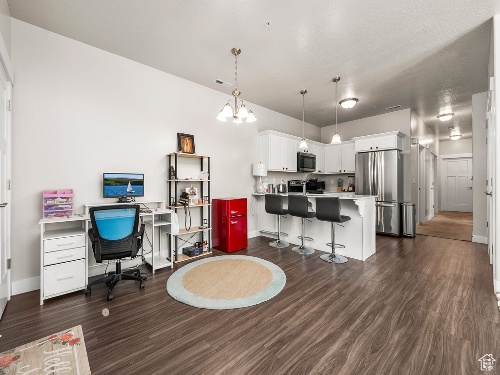 Office with dark wood finished floors and a chandelier