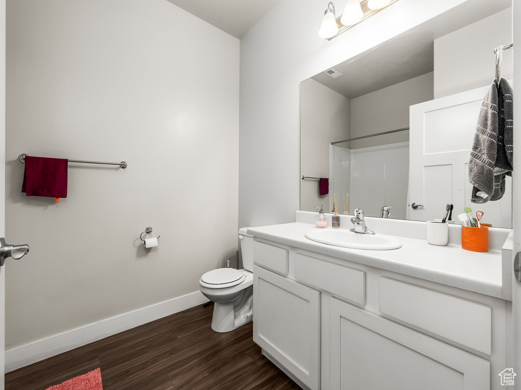 Bathroom featuring vanity, wood finished floors, and a shower
