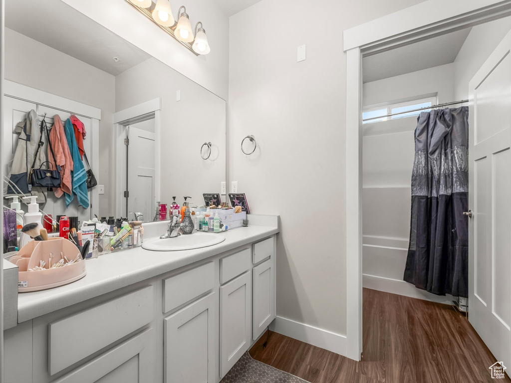 Bathroom featuring wood finished floors, vanity, and a shower with shower curtain