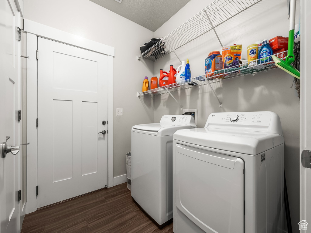 Laundry area with washer and clothes dryer and dark wood-style floors