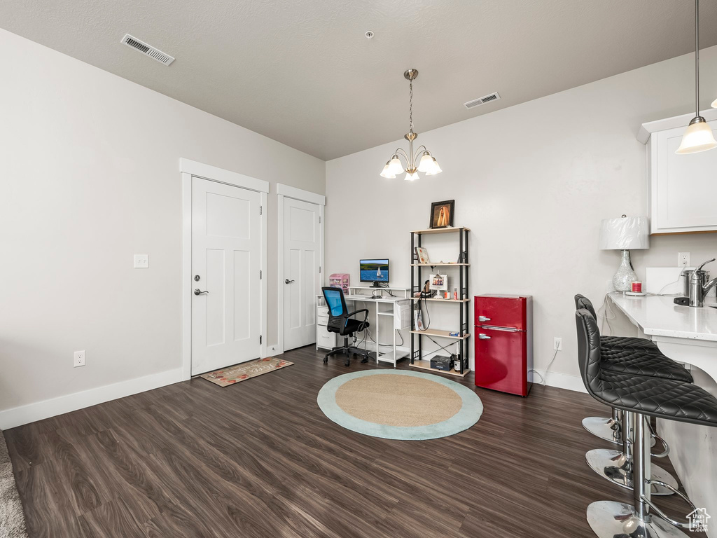 Office space with wood finished floors and a chandelier