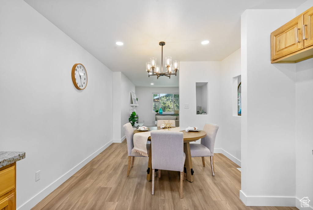 Dining room with light wood-type flooring, a chandelier, and recessed lighting