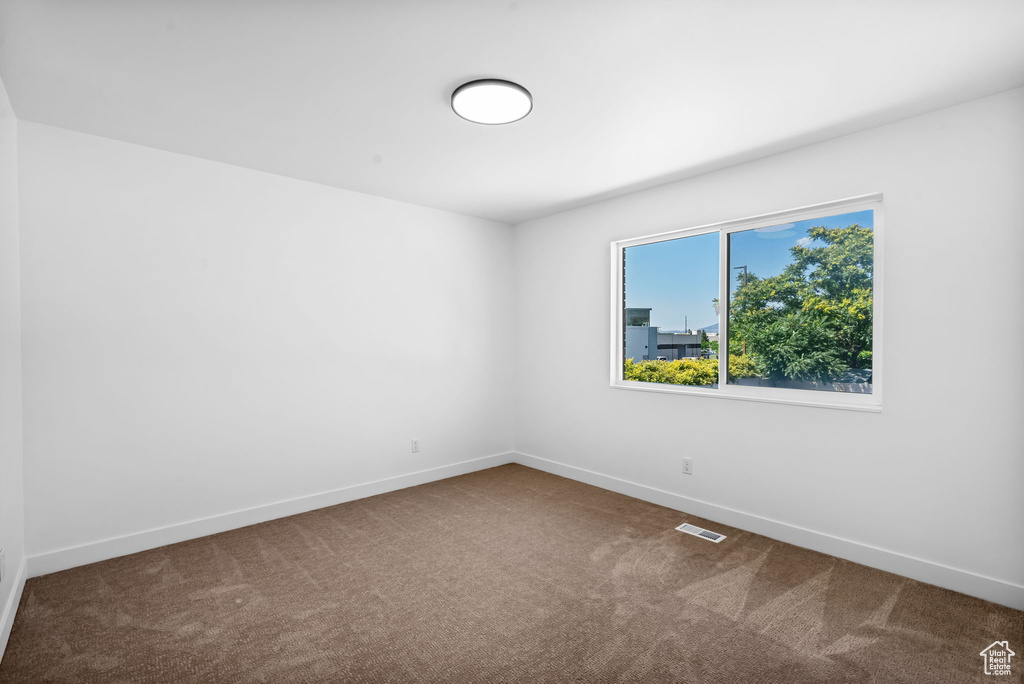 Carpeted spare room with baseboards