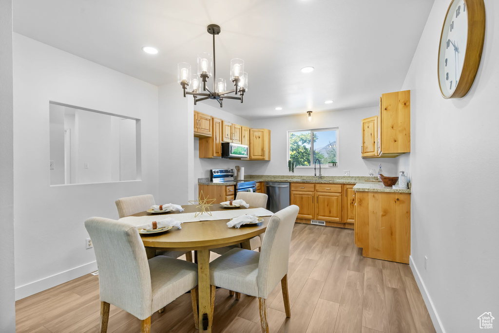 Dining room with a chandelier, light wood-style flooring, and recessed lighting