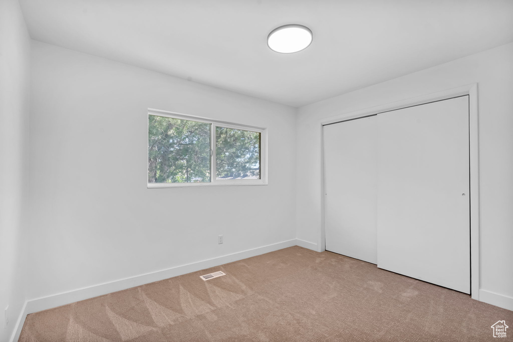 Unfurnished bedroom with carpet flooring and a closet