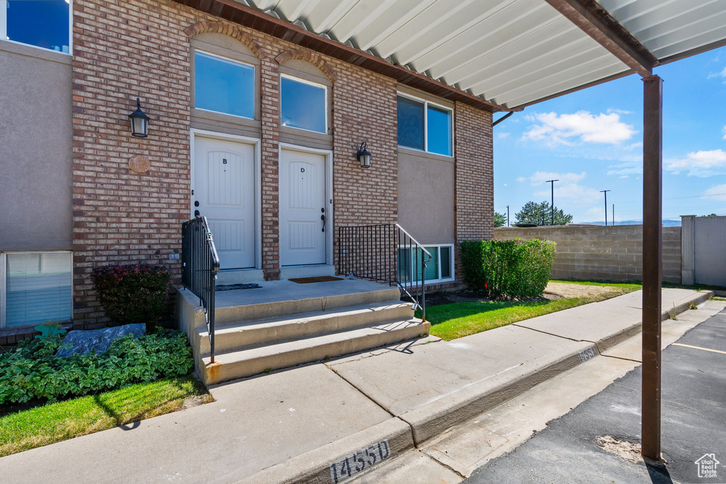 View of exterior entry featuring brick siding