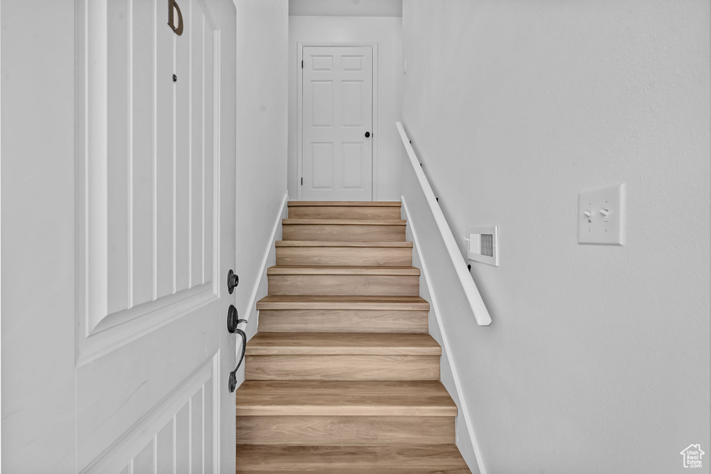 Stairway featuring baseboards and wood finished floors