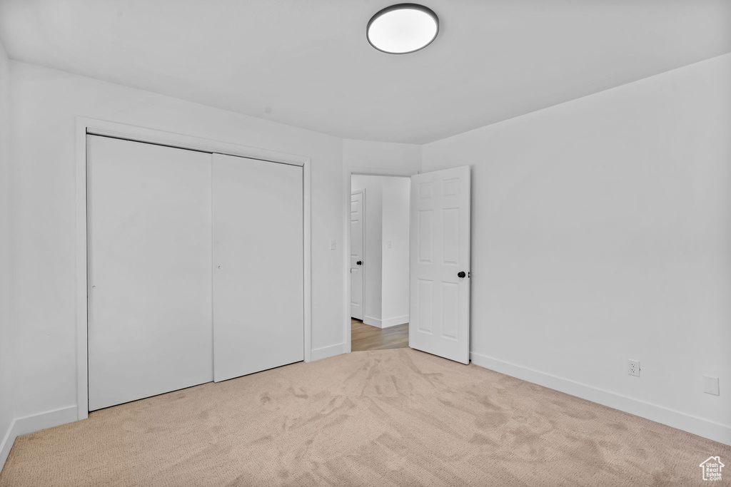 Unfurnished bedroom featuring carpet and a closet