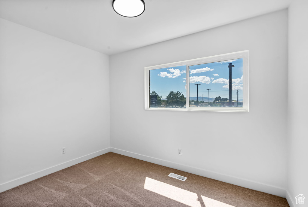 Carpeted spare room with baseboards
