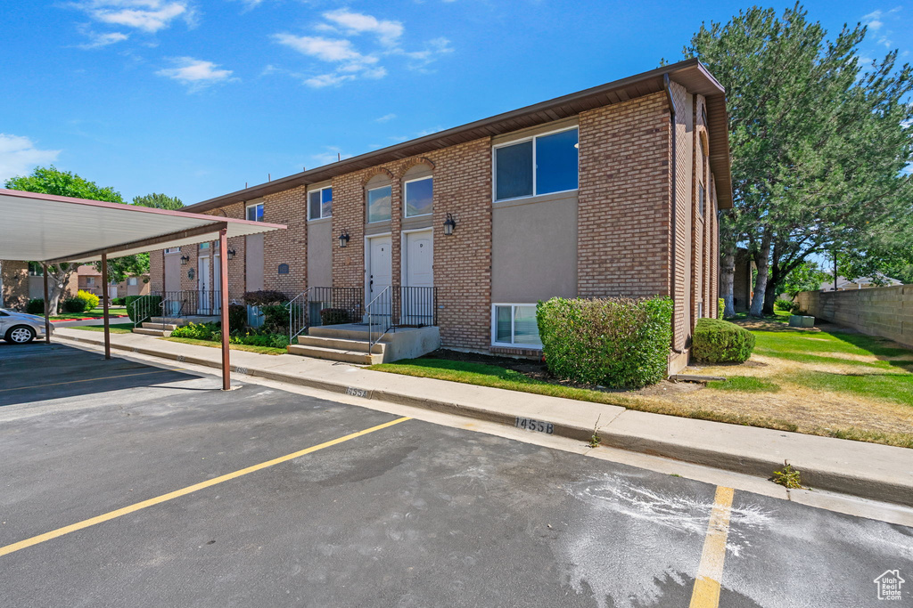 View of front of property with uncovered parking and brick siding