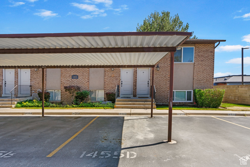 View of building exterior with covered and uncovered parking