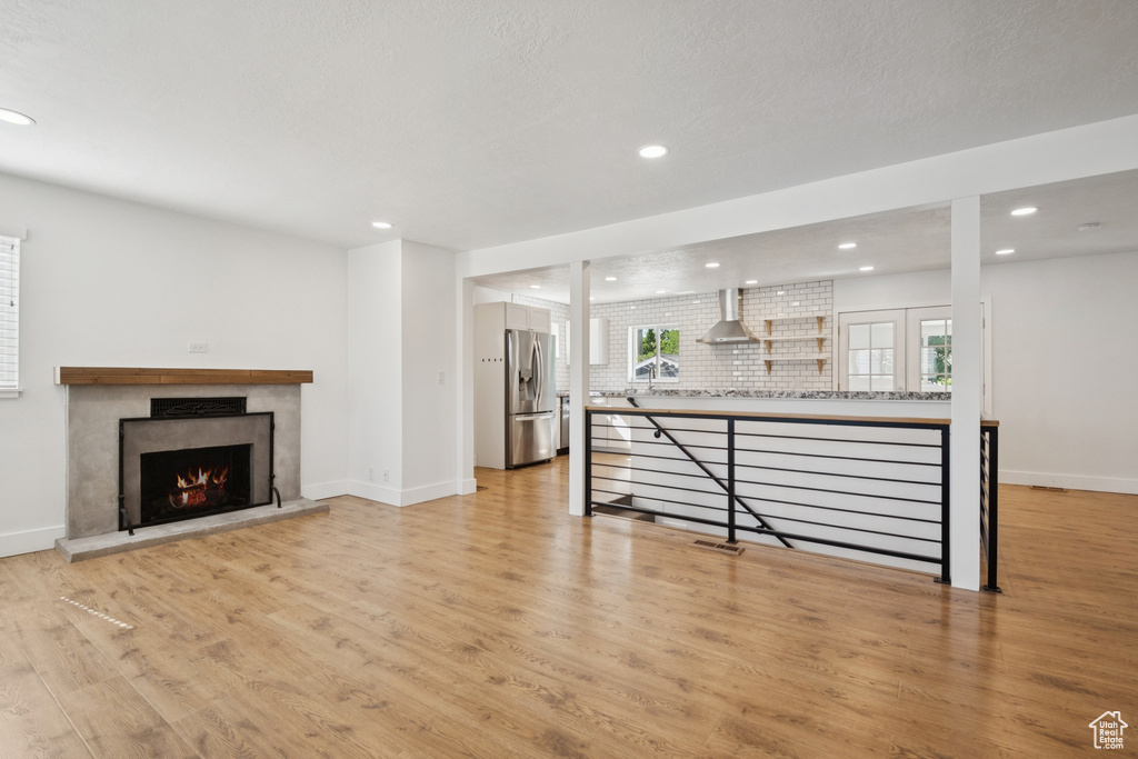 Living room with recessed lighting, light wood finished floors, and a fireplace