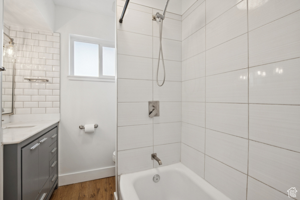 Bathroom with vanity, wood finished floors, and  shower combination