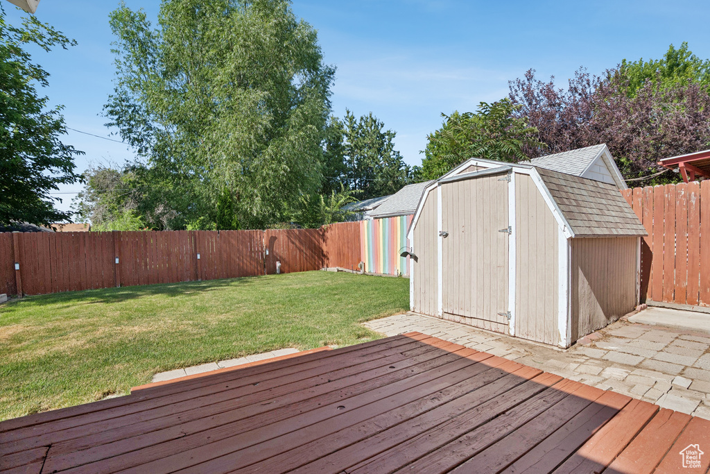 Wooden terrace with a storage shed and a fenced backyard