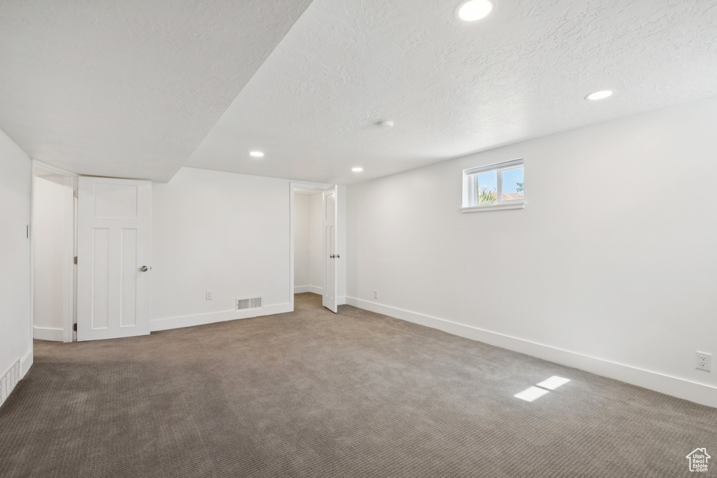 Below grade area with carpet floors, recessed lighting, and a textured ceiling