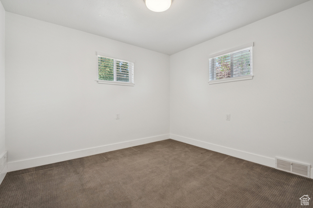 Carpeted spare room with baseboards
