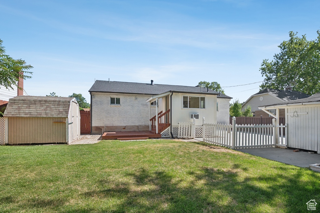 Back of property featuring a storage unit, a patio area, and brick siding