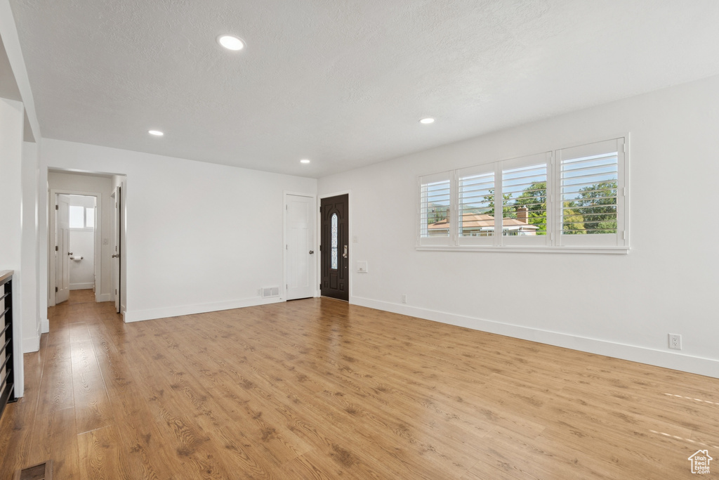 Empty room featuring plenty of natural light, light wood finished floors, and recessed lighting