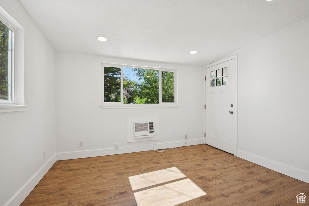 Spare room with recessed lighting, a wall mounted AC, and wood finished floors