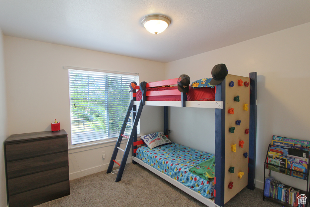 Carpeted bedroom featuring multiple windows
