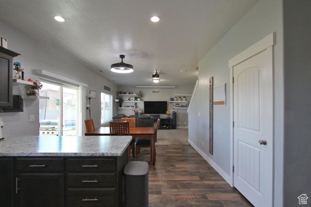 Kitchen with light countertops, a peninsula, dark wood-style floors, recessed lighting, and open floor plan