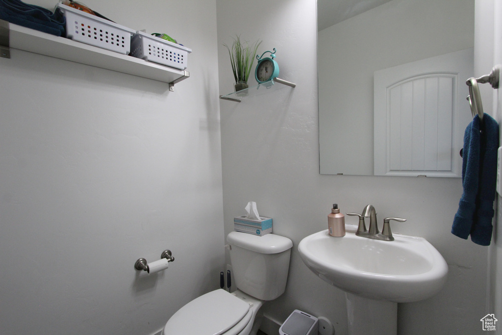 Half bath featuring toilet and a sink