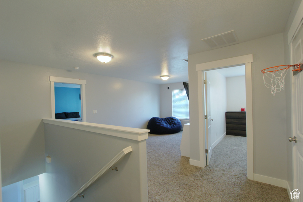Hall featuring light carpet and an upstairs landing